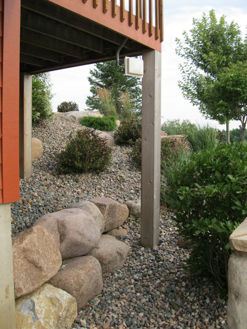Large stones retaining the elevated change below the raised porch